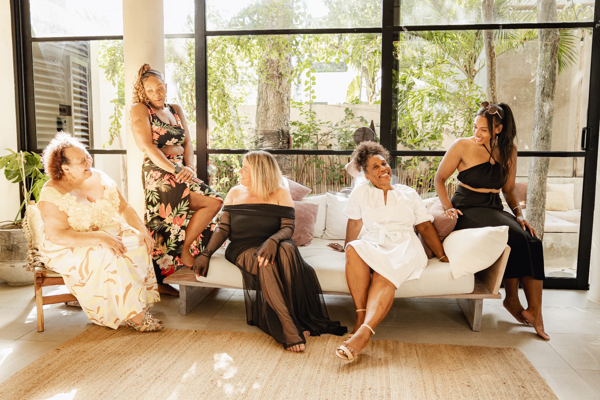 Women laughing together on a sofa at a Keep Me Curvy wellness retreat