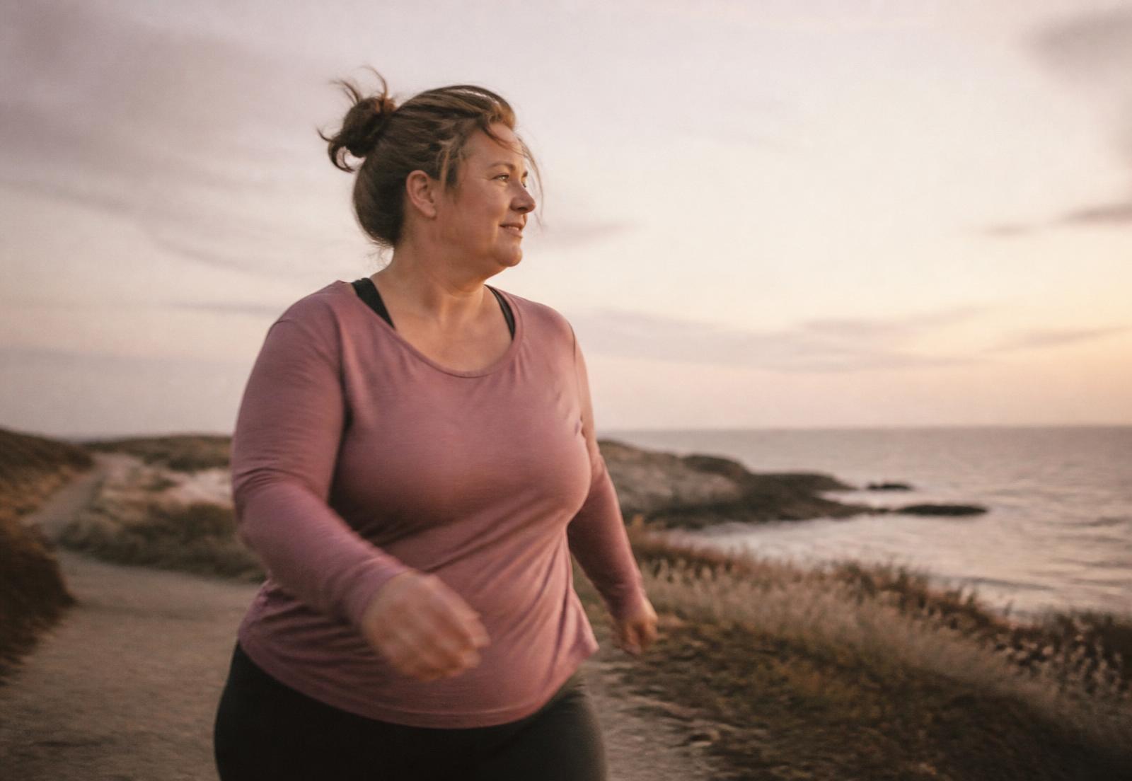 A woman walking a coastal path at golden hour